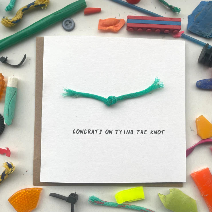Close-up of 'Congrats on Tying the Knot' wedding card, handmade with recycled microplastics on white card with a subtle texture.