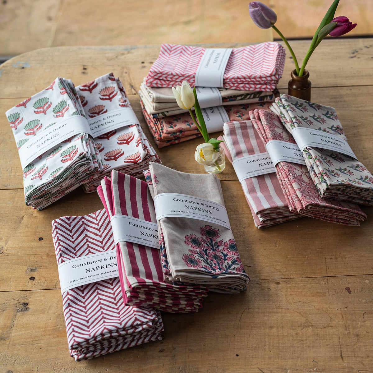 Set of 4 botanical meadow cotton napkins folded on a table