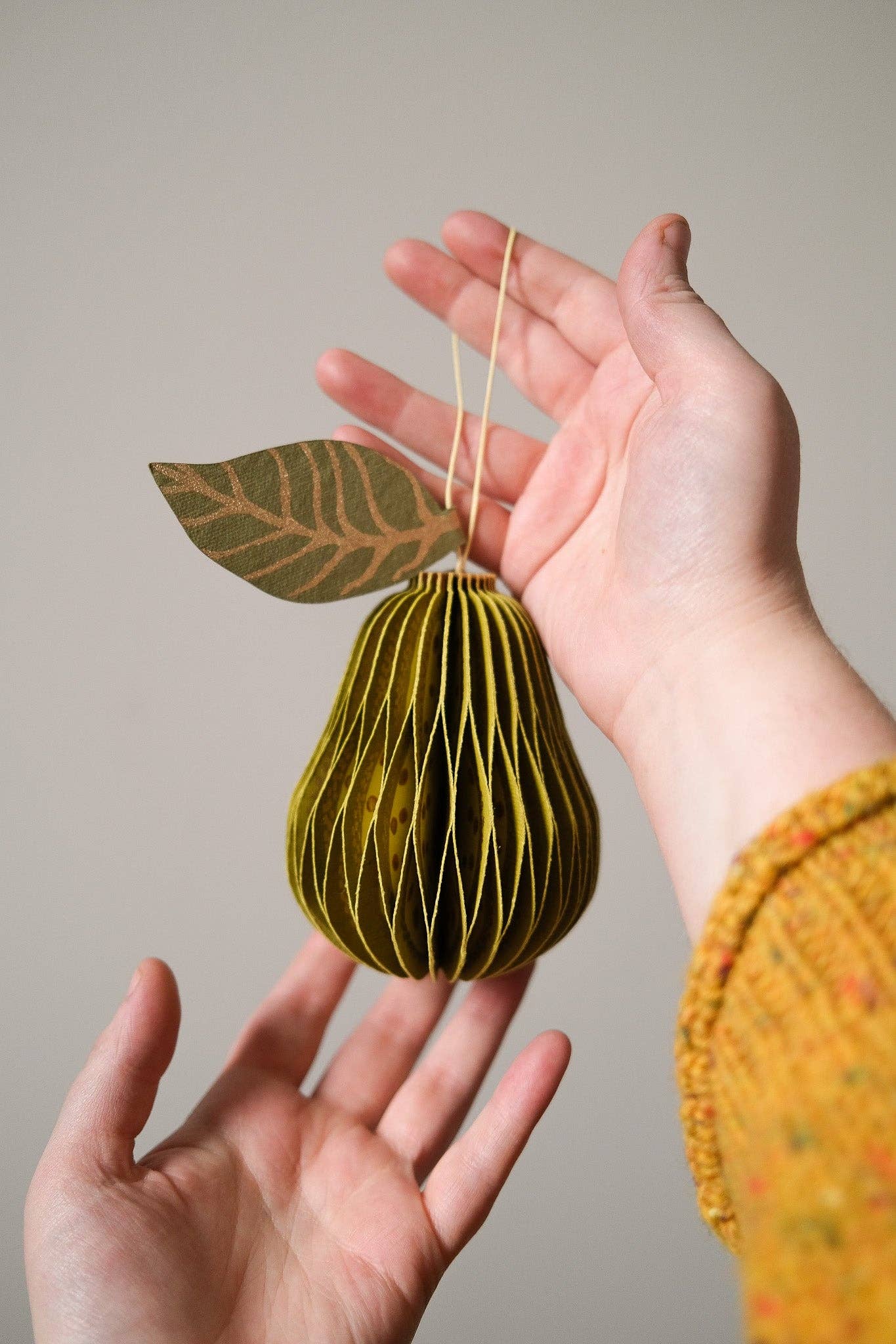 Pear honeycomb ornament partially folded, showing magnetic closure