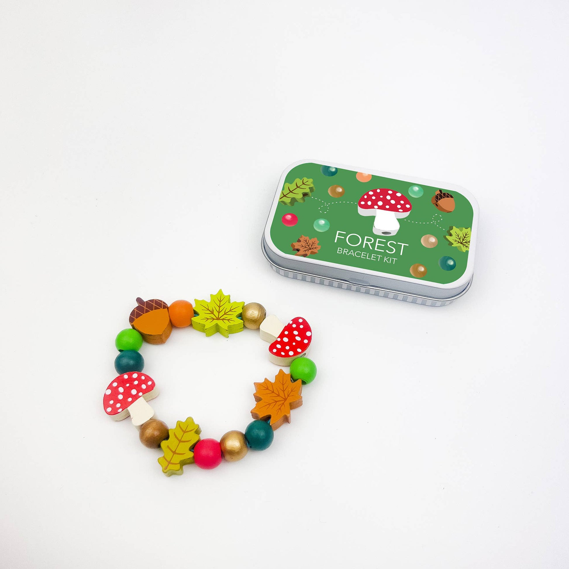 A beautiful gift tin containing elastic &amp; beads to create a beautiful wooden forest-themed bracelet. The elastic comes with metal ends to help children add beads with ease. The tin can be used to store the bracelet, or a special trinket