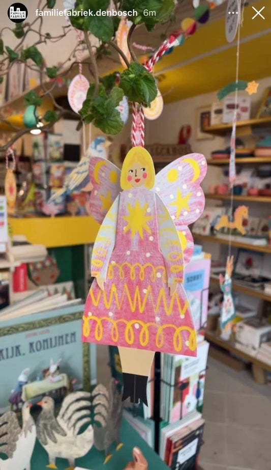 Stardust Butterfly Woman sitting card on a bookshelf