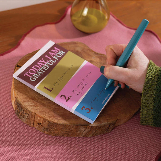 Eco-friendly A6 gratitude notepad on a wooden desk