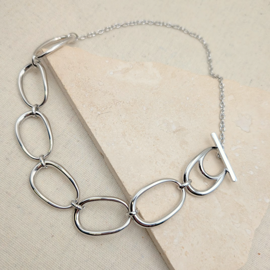Close-up of Little Nell Silver Pebble Link Statement Necklace, showcasing oval links and T-bar clasp