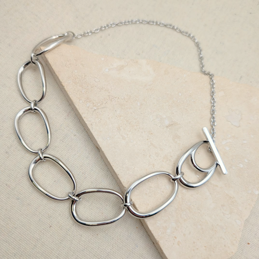 Close-up of Little Nell Silver Pebble Link Statement Necklace, showcasing oval links and T-bar clasp