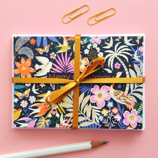 Festive Christmas notecard with colourful flora and fauna illustration on a dark background, 'Merry Christmas' text.