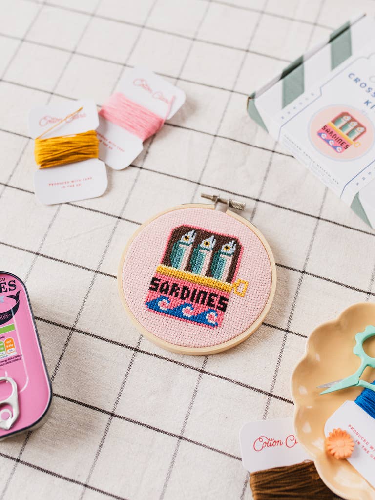 Sardines Cross Stitch Kit for beginners, featuring a 4-inch wooden hoop, coloured Aida fabric, embroidery thread, and eco-conscious packaging. Made in UK.
