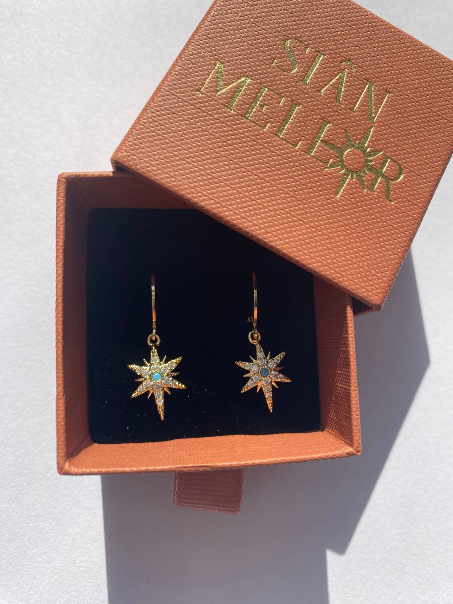 Gold star huggie hoop earrings with turquoise centre