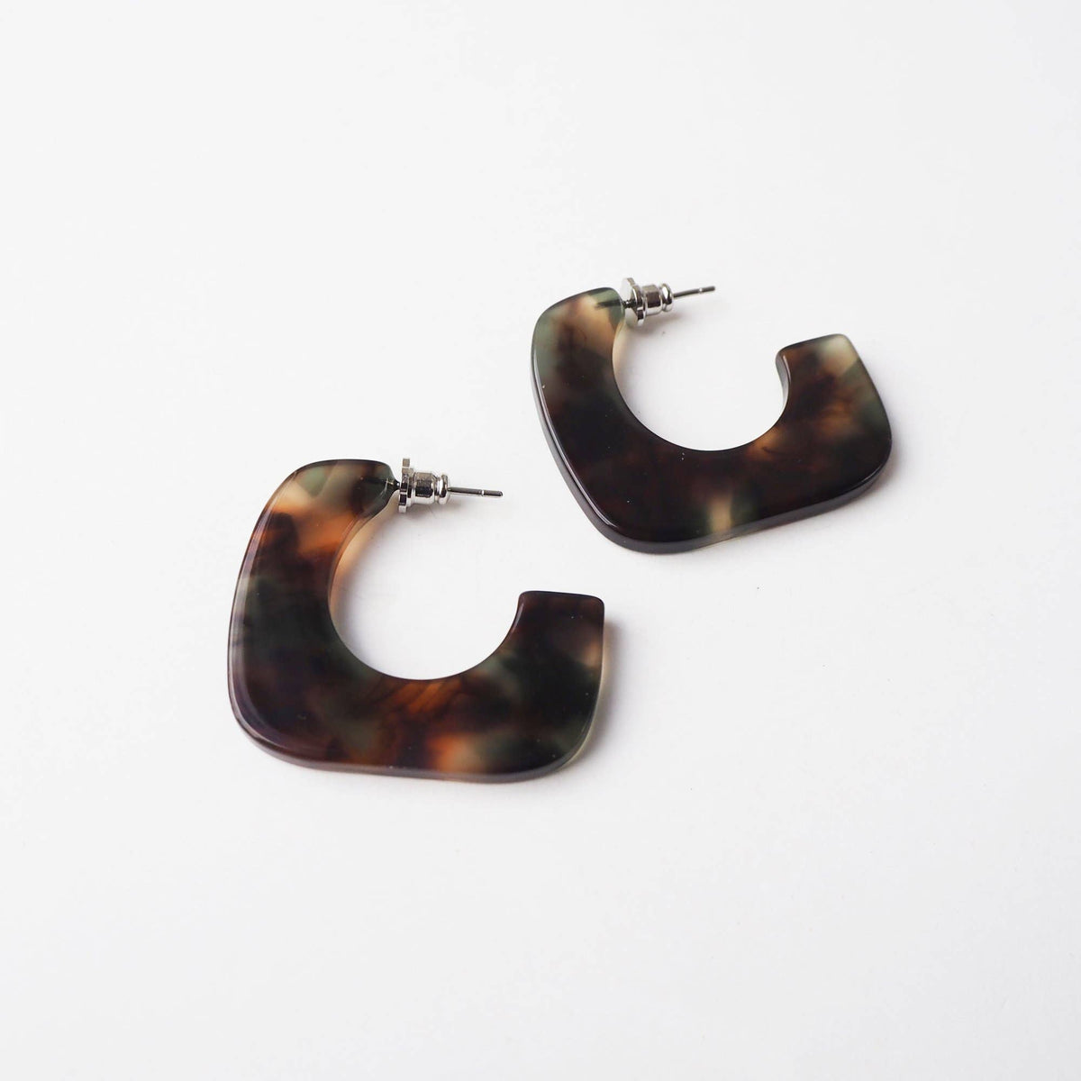 Green and brown patterned acetate square earrings on branded card