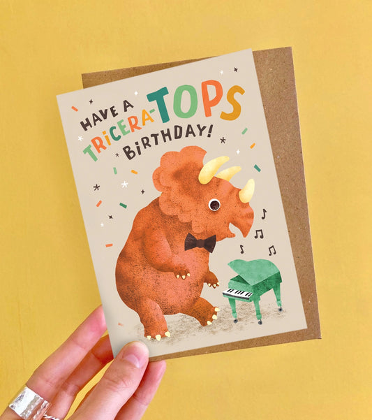 Birthday card with triceratops illustration and text on a yellow background
