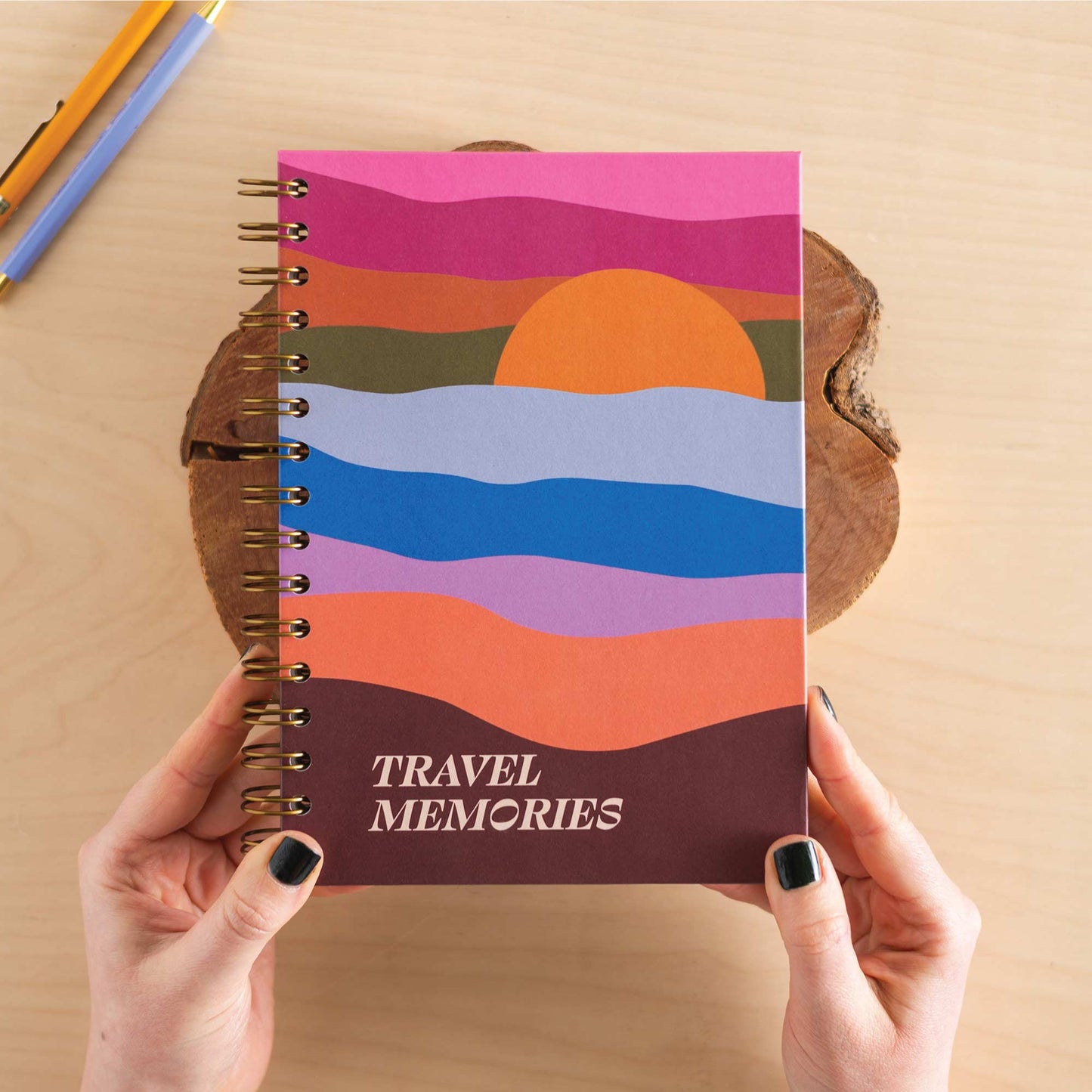 Stack of A5 Wanderlust Hardcover Travel Journals with vibrant sunset covers