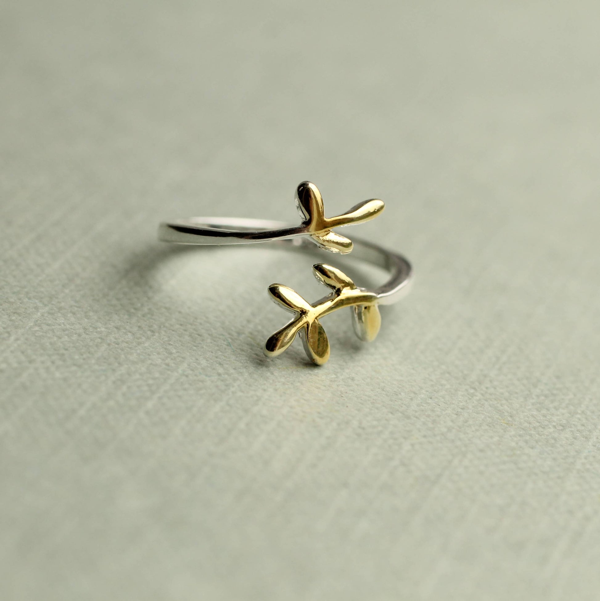 This sweet and delicate botanical inspired ring is made from Sterling silver, with touches of gold plating on the tips. The ring has an open, or adjustable form which can fit most fingers.