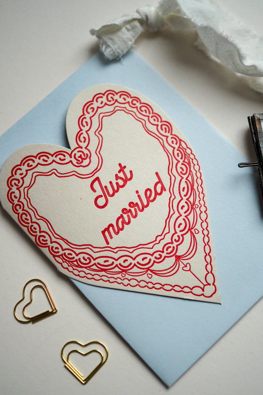 A letter press greeting card featuring a hand drawn retro cake in red and the words Just married.