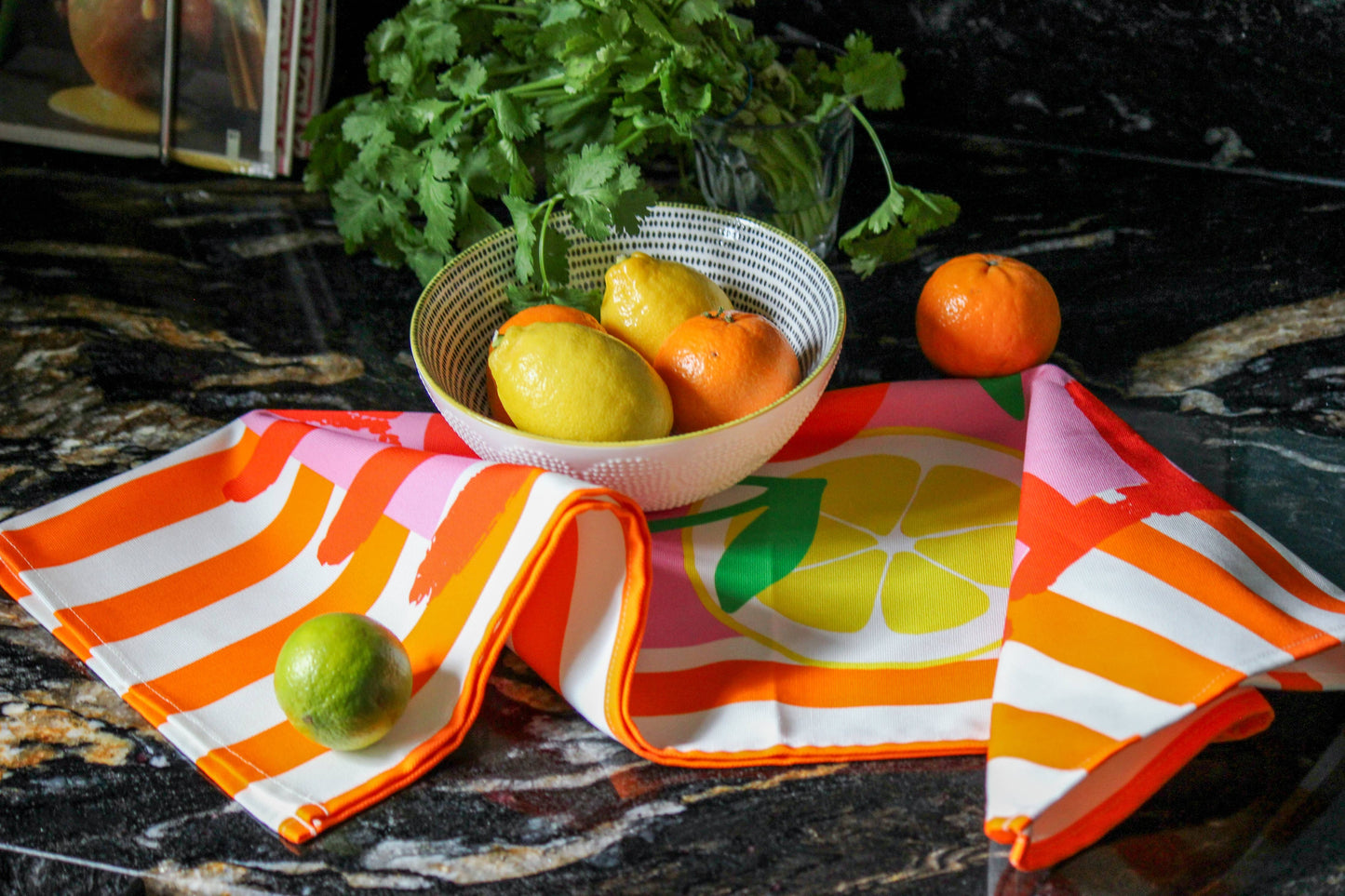 Vibrant fruit print tea towel folded with paper belly band