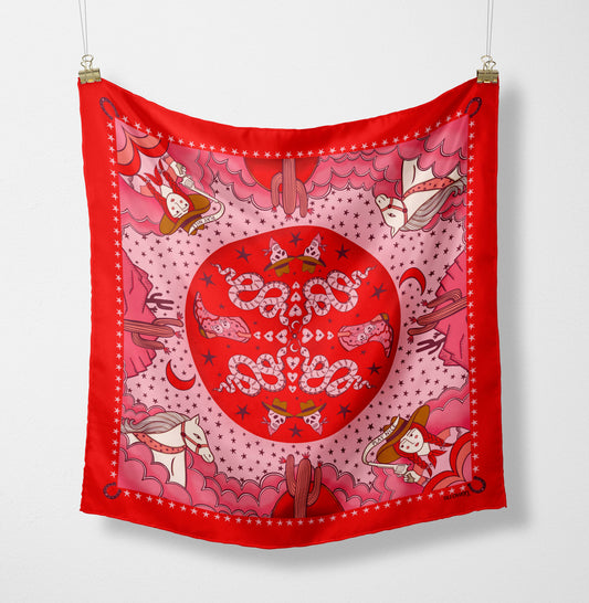Eco silk twill pocket square with sassy cowgirl and white stallion, cacti, stars, boots, snakes, mountains, and horseshoe border in red and pink. Made from recycled polyester, designed by Su Owen.