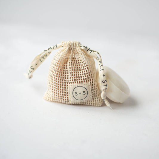 Natural cotton storage bag hanging with shampoo bar drying inside