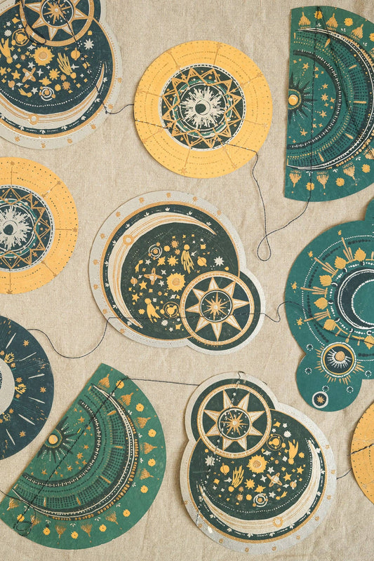 Close up of hand screen-printed paper star and moon garland