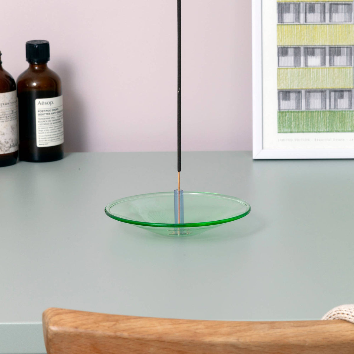 Colourful glass incense holder with burning incense stick
