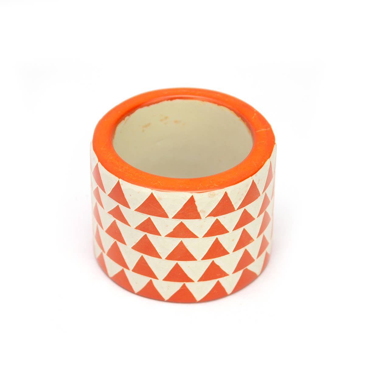 Hand Carved Soapstone Napkin Ring 'Orange Triangles'. Made in Kenya. Shown with an AARVEN Napkin, against a blue placemat.