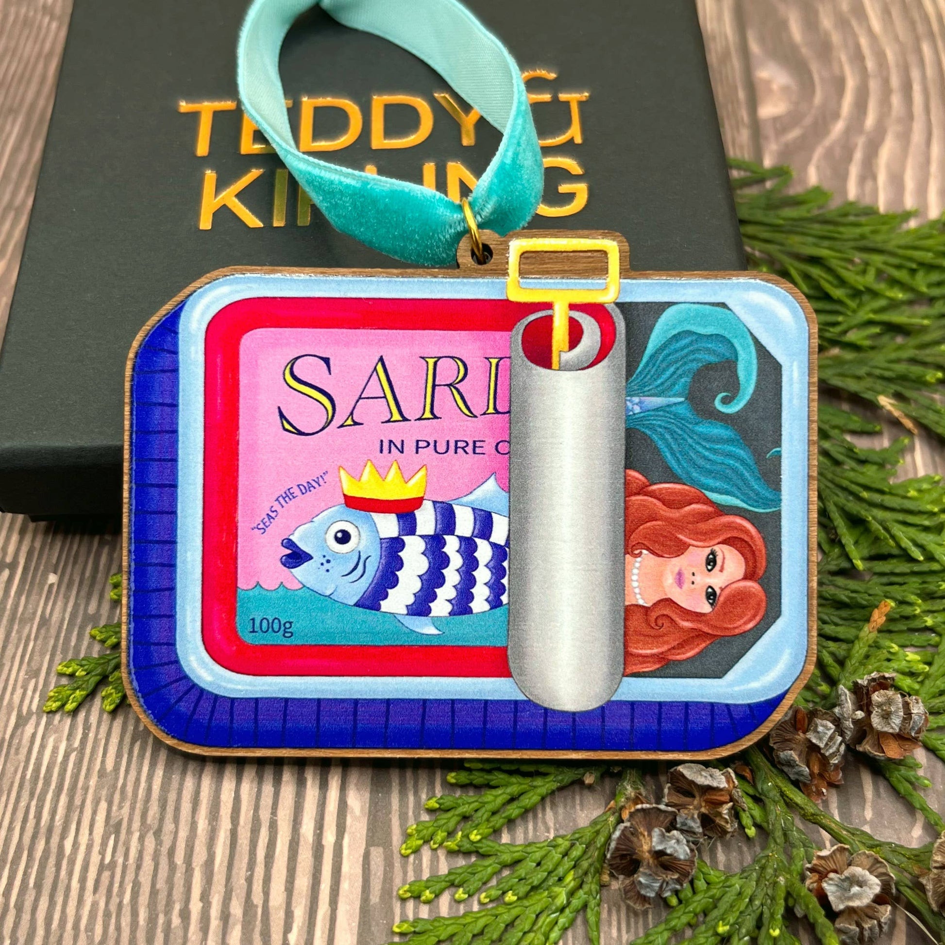 Sardine Tin Mermaid wooden Christmas tree decoration with Teddy & Kipling illustration, sustainably certified cherry wood, gold-plated ring, and turquoise velvet ribbon