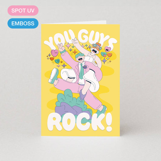 Colourful embossed and spot UV “You Guys Rock” wedding card featuring a happy couple illustration, A6 size, eco-friendly, UK made.