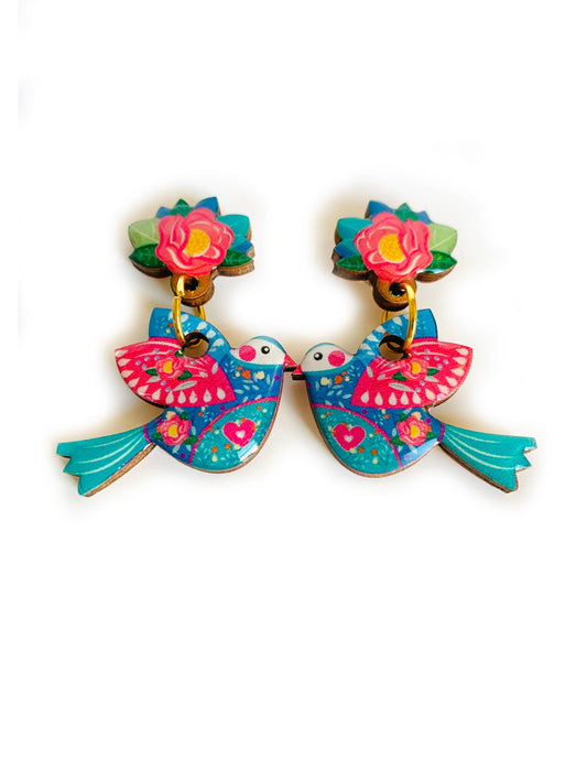 Playful kissing bird earrings designed by Rosie Rose Parker. Lightweight dangles in blue-green and pink, coated with resin for a glass-like finish. Beautifully detailed and handmade. Flower is the stud area and the dangle is the bird.