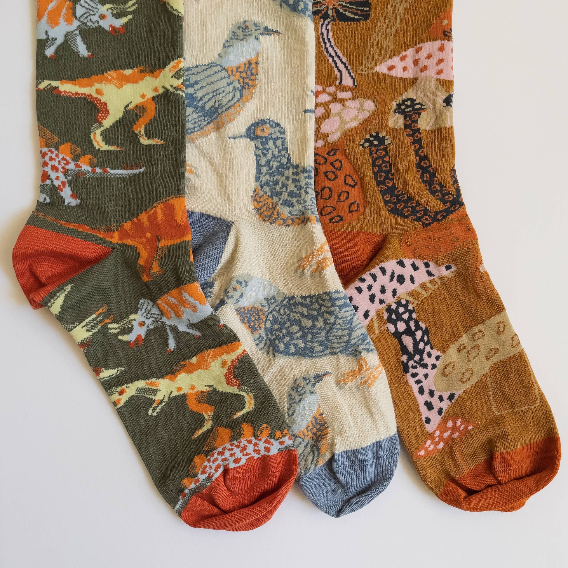 Three pairs of socks with animal pattern designs on a white background