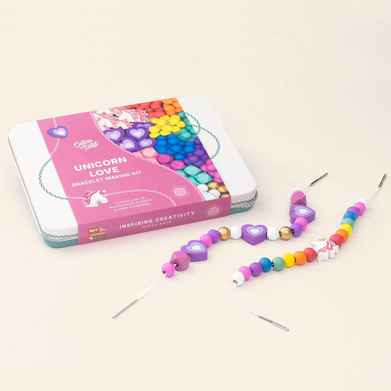 Colourful wooden beaded bracelet with 'Unicorn Love' bracelet making kit on a beige background