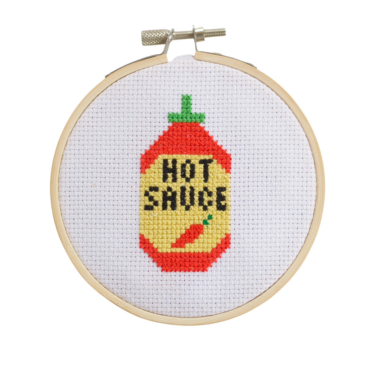 Completed hot sauce bottle cross stitch design in kitchen
