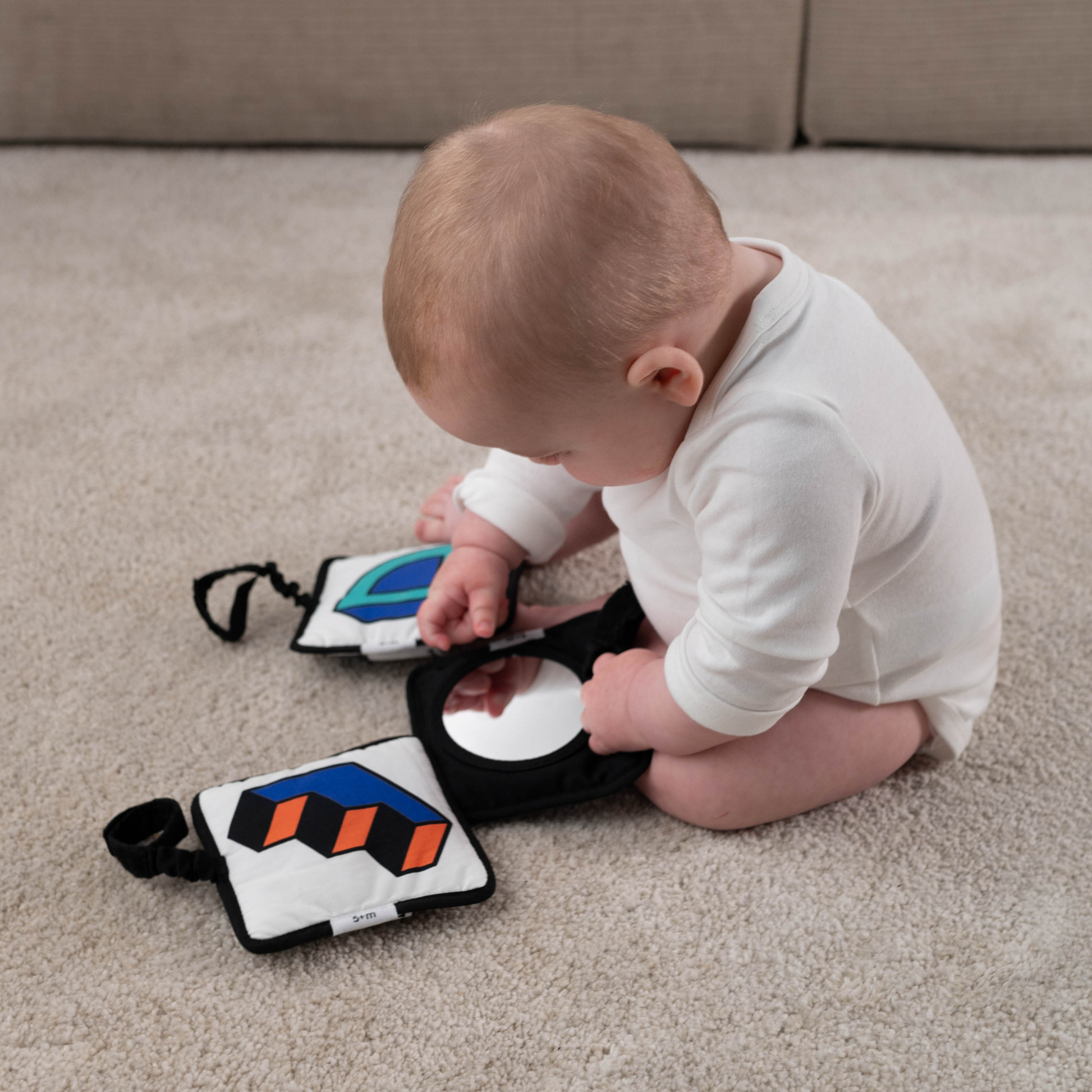 Baby interacting with Etta Loves x Walala Sensory Hanging Square on a baby gym