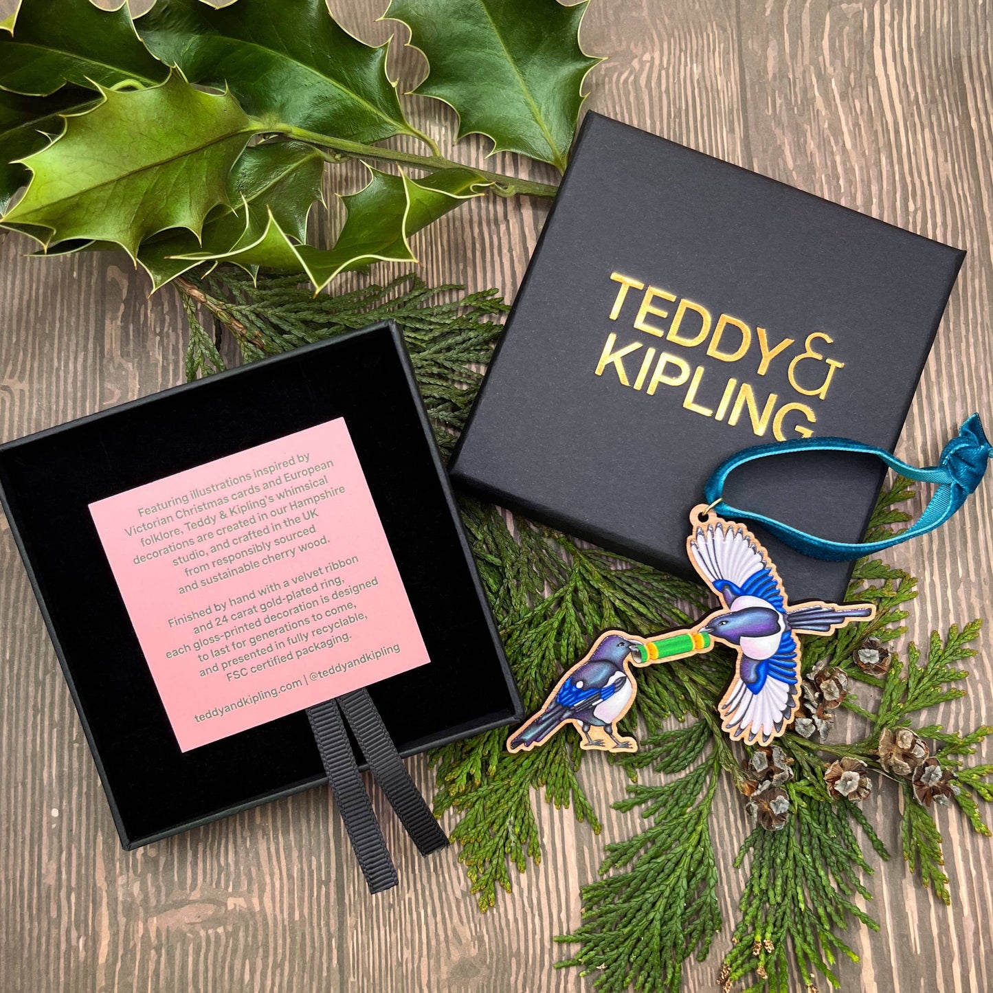 Magpie wooden Christmas tree decoration featuring Teddy & Kipling illustration, sustainably certified cherry wood, gold-plated ring, and dark teal velvet ribbon