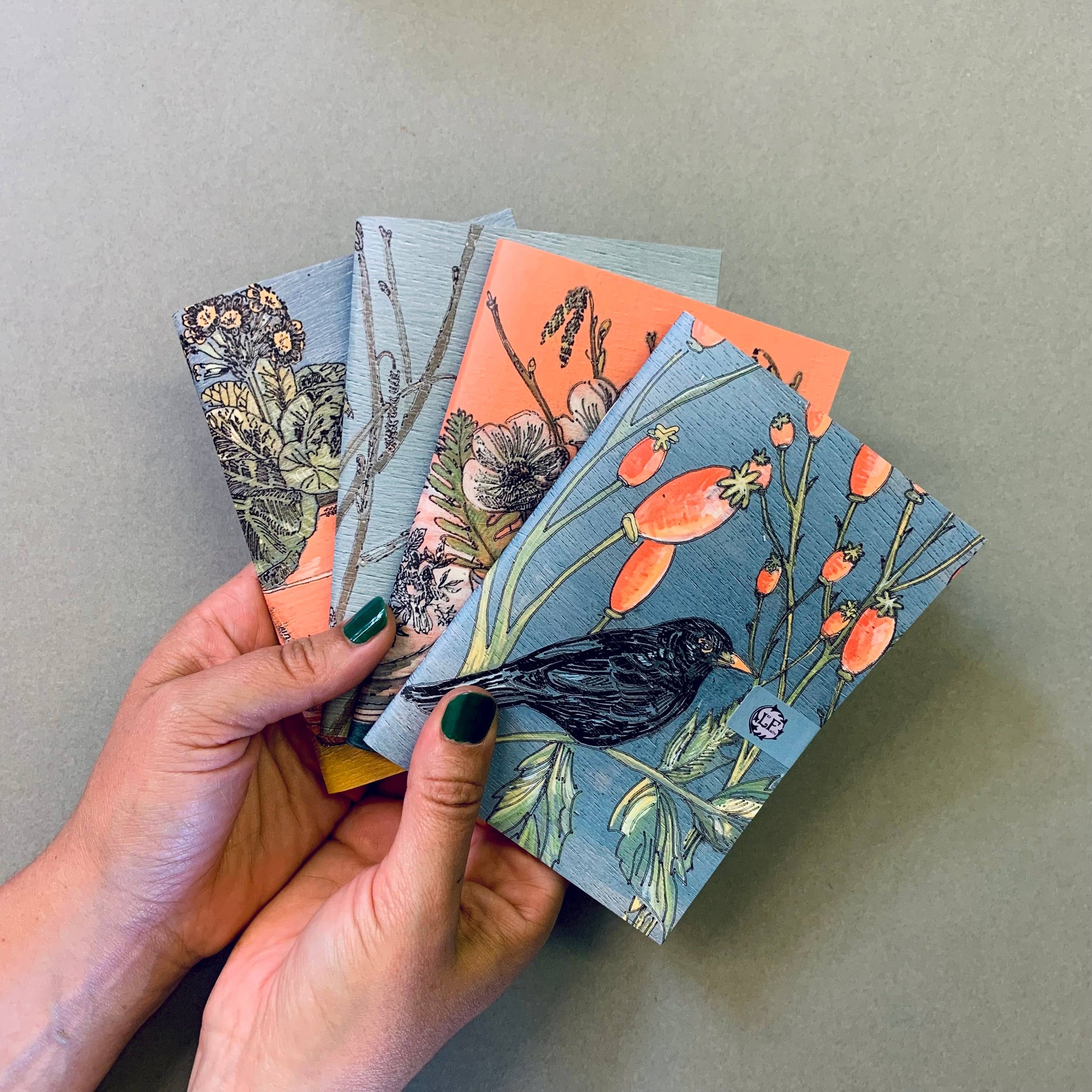 A selection of Lilly Faith's  A5 Notebooks, which are illustrated with birds and flora.