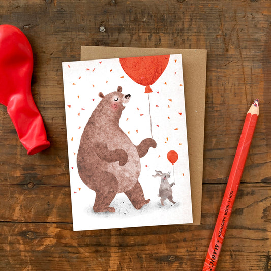 A6 greeting card showing a hand-collaged bear and bunny dancing illustration by Emily Nash, blank inside, paired with a recycled kraft envelope.