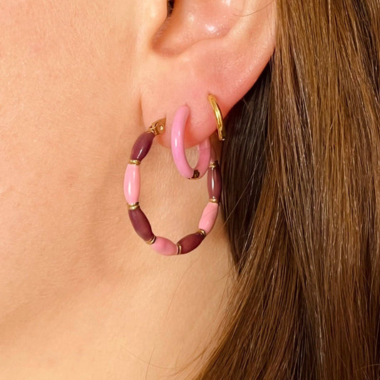 Model wearing colourful candy striped hoop earrings, 31mm, gold plated, playful style.