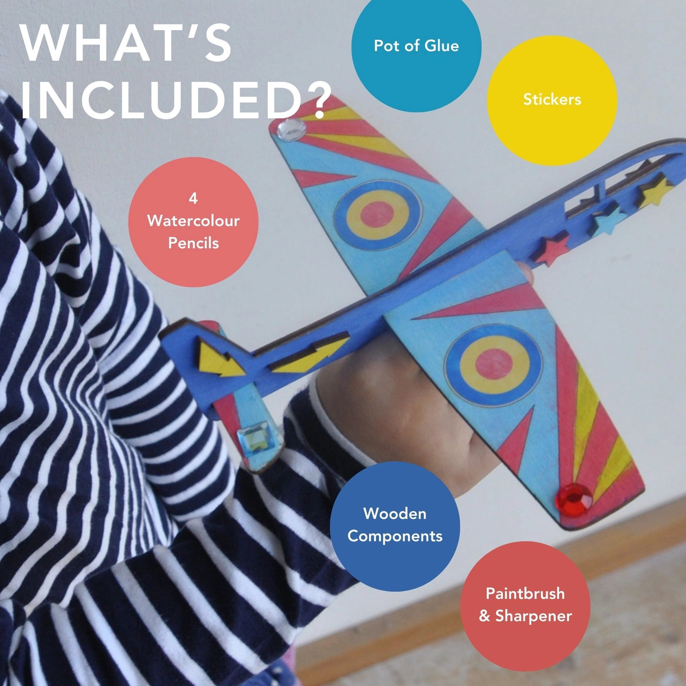 Close-up of the wooden plane components and colourful jumbo watercolour pencils included in the craft kit.