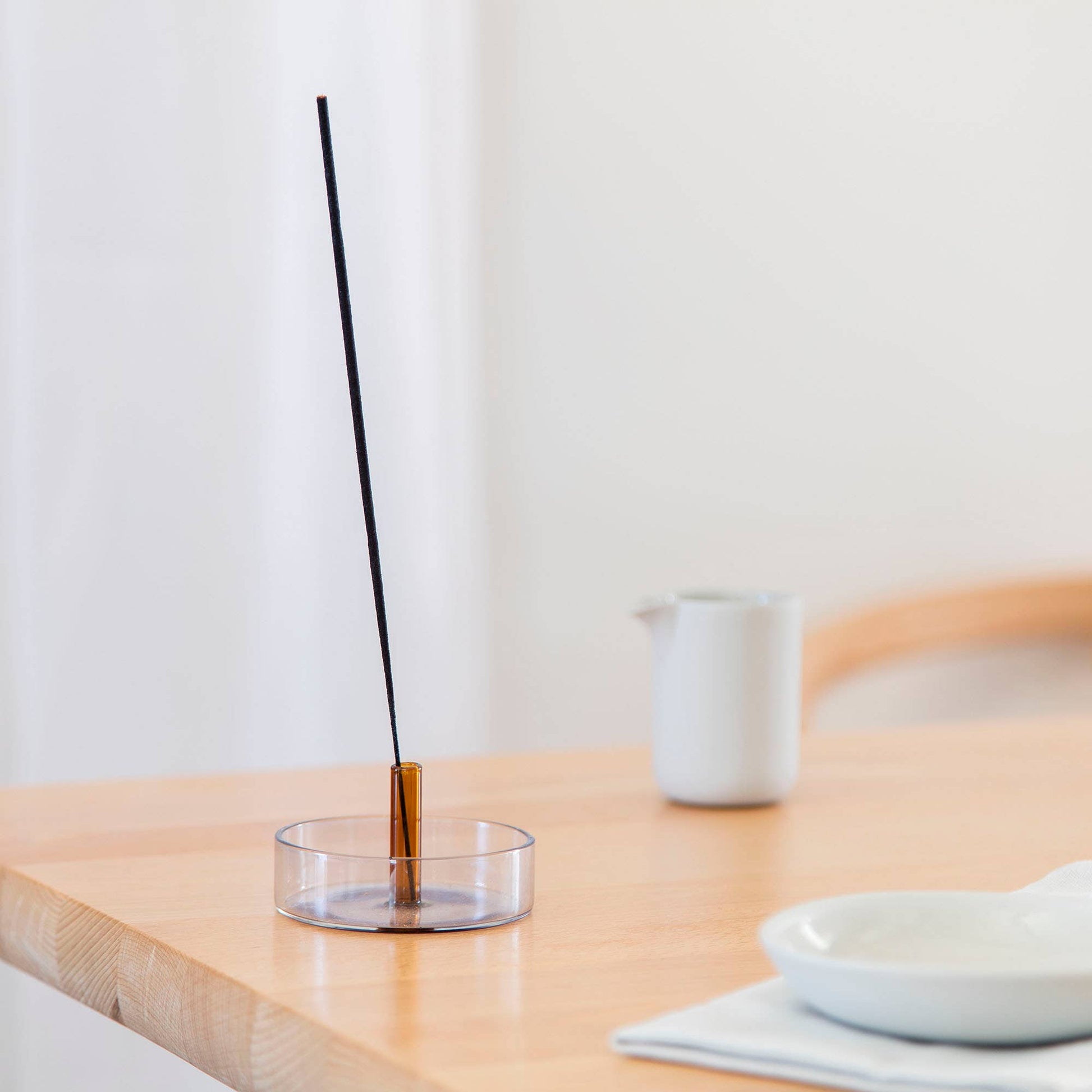 Duo Tone Incense Holder on a stylish shelf with an incense stick