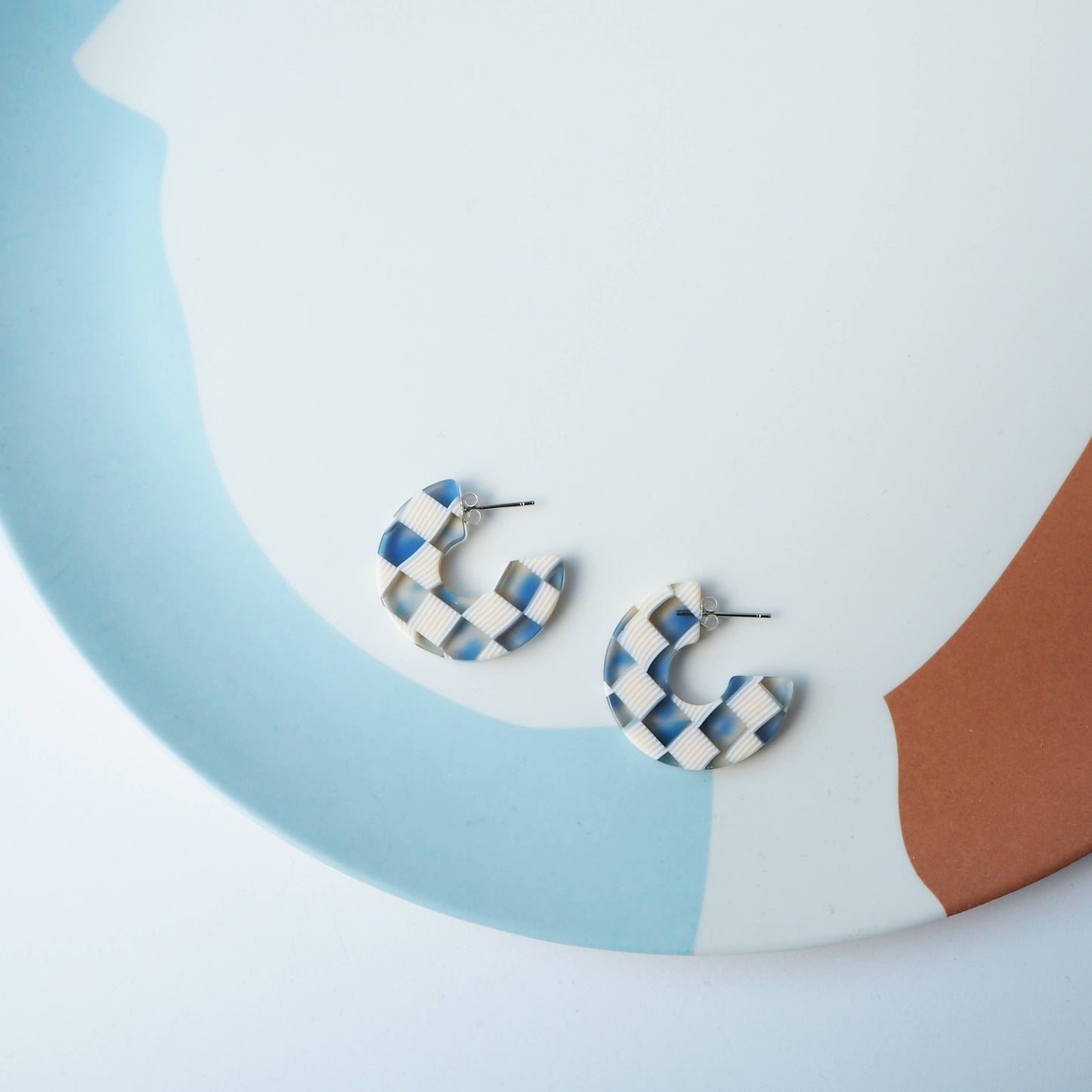 Sustainable blue resin hoop earrings on branded card