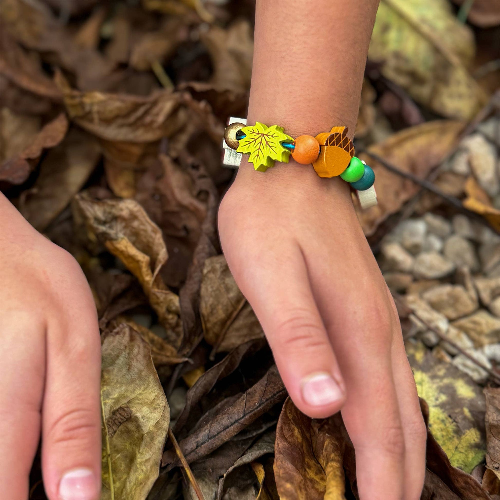 A beautiful gift tin containing elastic &amp; beads to create a beautiful wooden forest-themed bracelet. The elastic comes with metal ends to help children add beads with ease. The tin can be used to store the bracelet, or a special trinket