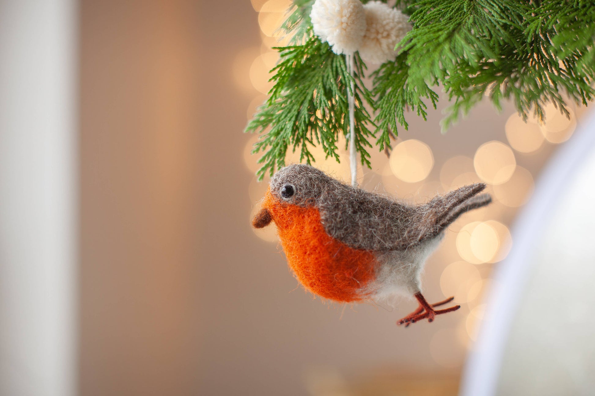 Handmade Robin Christmas decoration with detailed needle felting, beady glass eyes, and pom pom hanger, perfect for eco-friendly holiday decorating.
