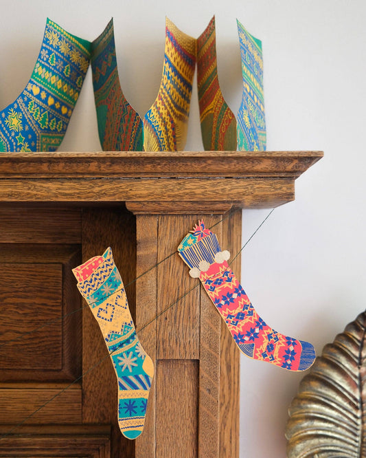Close-up of hand-printed recycled paper stockings garland designs