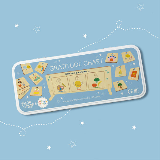 Close-up of a child placing a gratitude token on the wooden chart stand