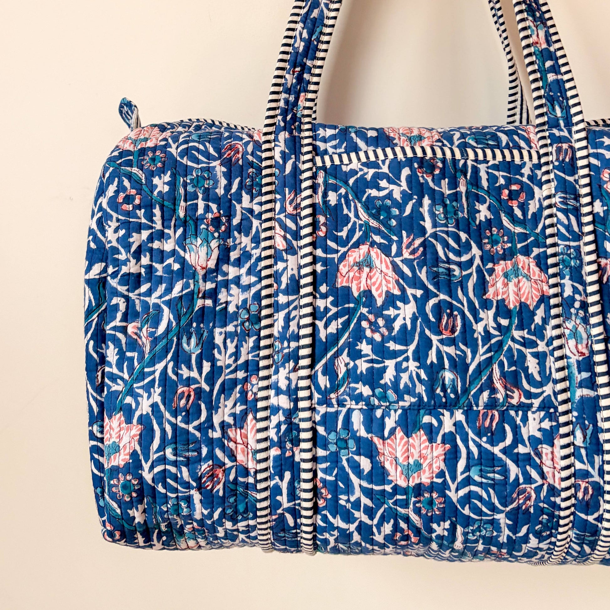 Inside view of quilted cotton weekend bag showing striped lining and pocket