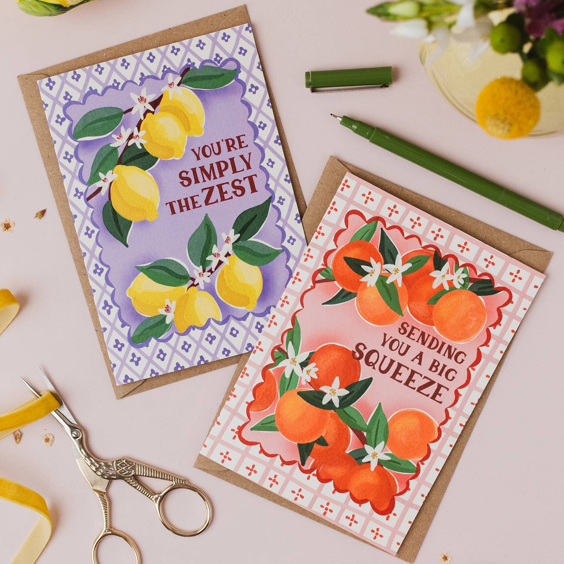 Stack of 'Big Squeeze' orange greeting cards with kraft envelopes, showing plastic-free banding