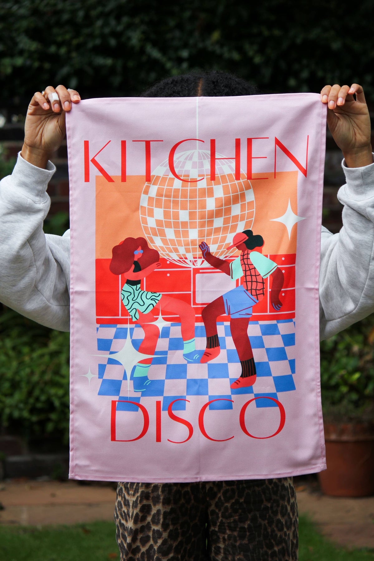 Pink disco dancing cotton tea towel hanging in a colourful kitchen
