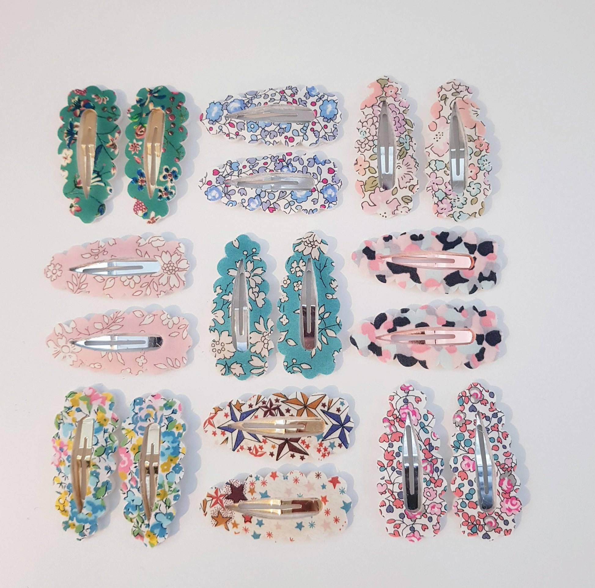 Collection of floral and patterned hair clips on a light gray background