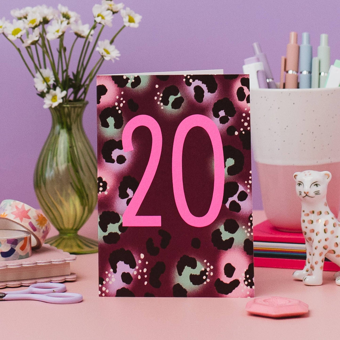 Close-up of neon pink '20' on leopard print birthday card