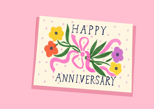 A joyful card to celebrate an anniversary, featuring an illustration of brightly coloured flowers all tied up in a pink bow. With the words Happy Anniversary.