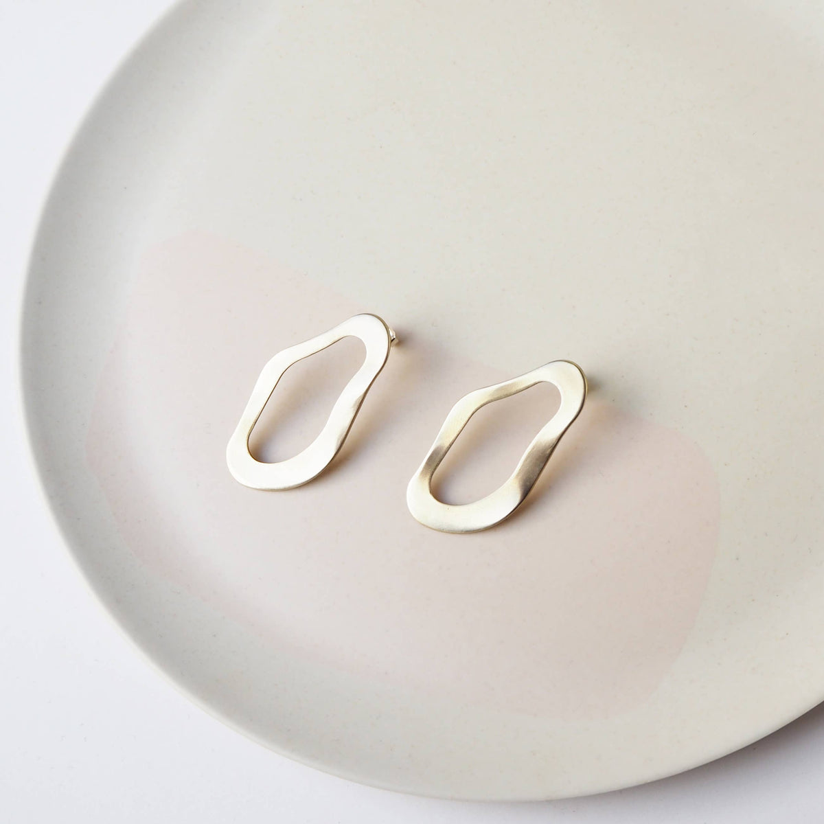 Minimalist gold brass stud earrings close-up