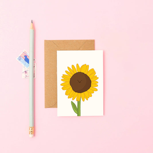 Close-up of a smiling sunflower mini A7 card, showcasing hand-drawn detail and eco-friendly recycled Kraft envelope.