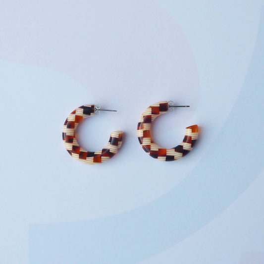Honey checker acetate hoop earrings on a branded display card