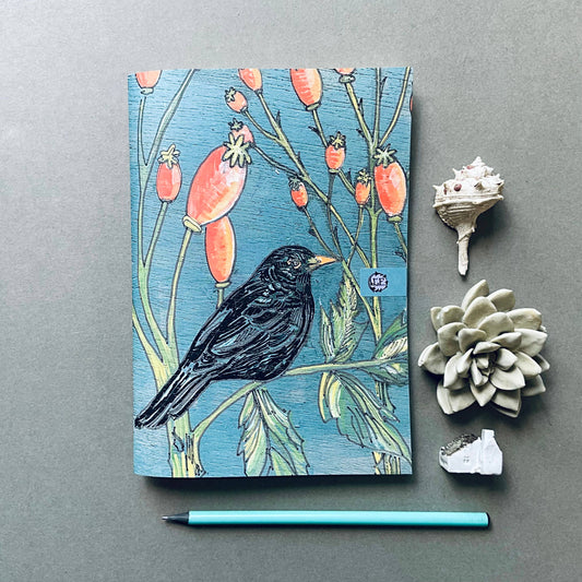 Lily Faith's etched and engraved Blackbird in the Rosehips illustration beautifully transposed onto a pocket sized A5 notebook. With a lovely weight to the centre pages, they are left blank for your thoughts and drawings to take life.